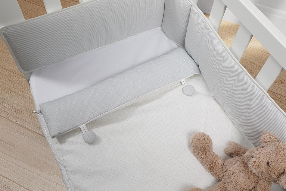 Kit protetor de berço Micuna com edredão saco na cor Branco, mostrando o protetor baixo e o saco com fecho de correr.