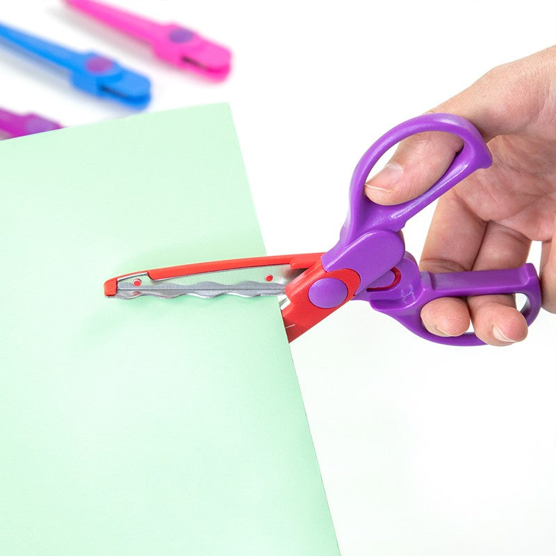 Tesoura Milan em uso, realizando um corte decorativo em papel, evidenciando a versatilidade do kit.