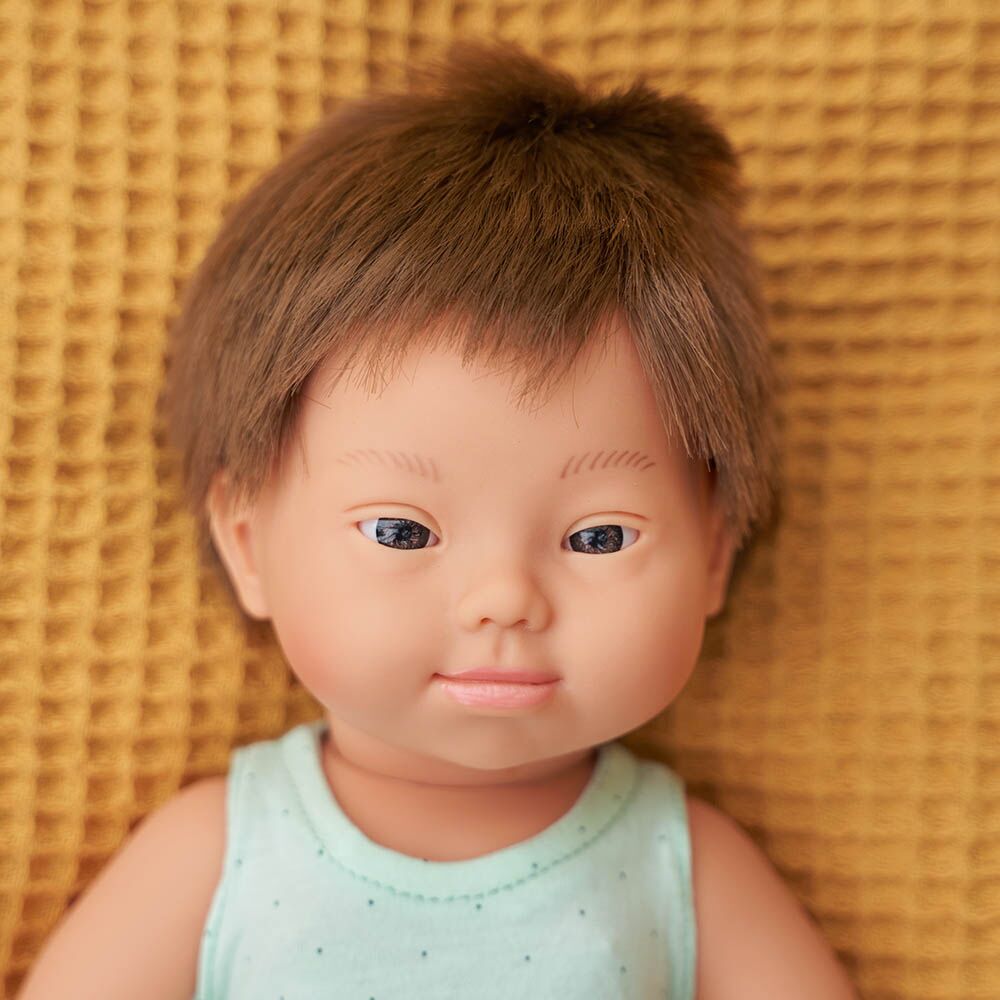 Boneco bebé Miniland caucasiano de 38cm, com cabelo loiro e olhos azuis, vestido com roupa interior branca, em pose de pé.