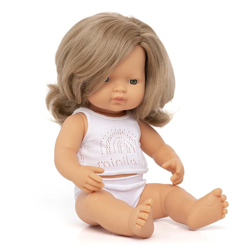 Boneco bebé Miniland caucasiano de 38cm, sentado sobre fundo branco, vestido com roupa interior branca, mostrando articulações.