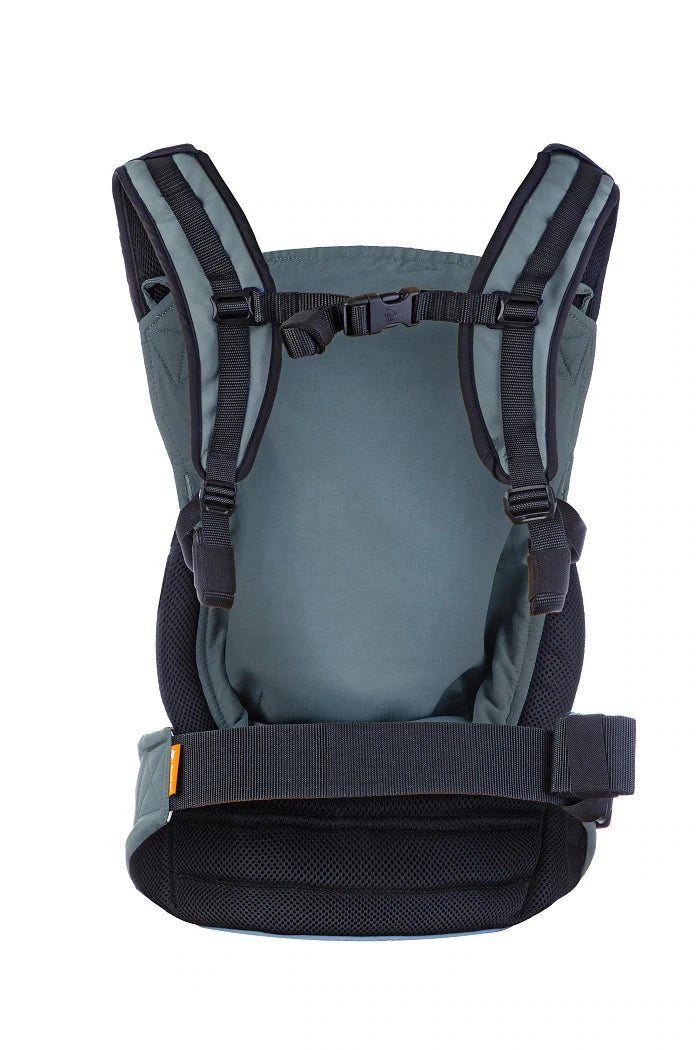 Vista lateral da mochila Tula Lite Slate com o bebé posicionado na frente, virado para dentro, demonstrando o suporte ergonómico.
