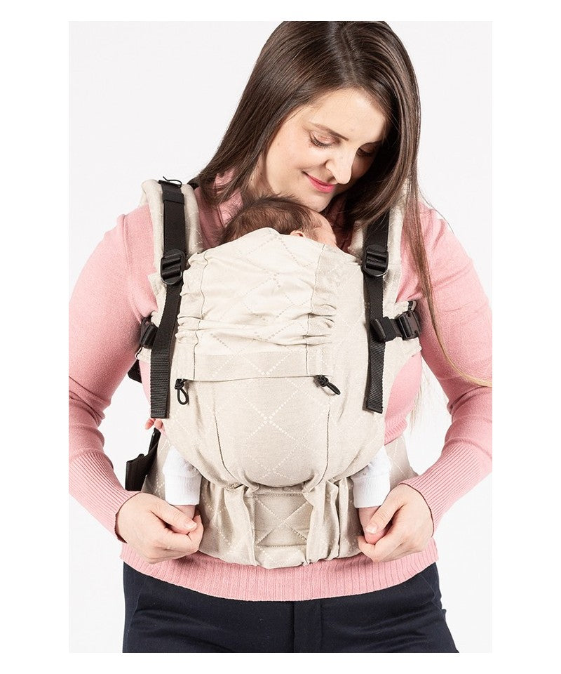 Mochila ergonómica Isara THE One em linho "AU NATUREL", vista frontal com bebé a ser transportado de frente (barriga com barriga), mostrando o ajuste perfeito.
