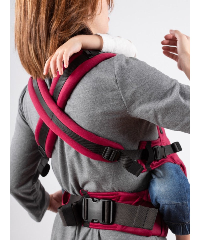 Mochila porta-bebés Isara THE One ajustável na cor Scarlet (vermelho-rubi) totalmente montada, exibindo design ergonómico e tecido vibrante.