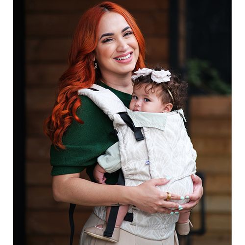 Bebé transportado na mochila Neko Switch, em posição ergonómica (joelho a joelho), com o tecido Lino Perla visível.