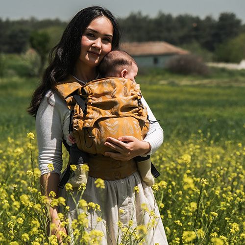Mochila ergonómica Neko Switch ajustável, cor azul/turquesa, vista frontal com bebé posicionado corretamente, mostrando suporte lombar e ajuste do painel.