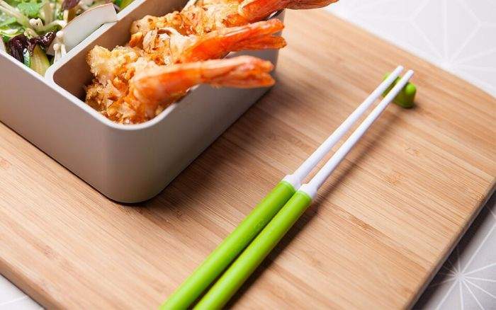 Par de pauzinhos Monbento de cor verde-esmeralda, com pontas texturizadas, prontos a usar em refeições.