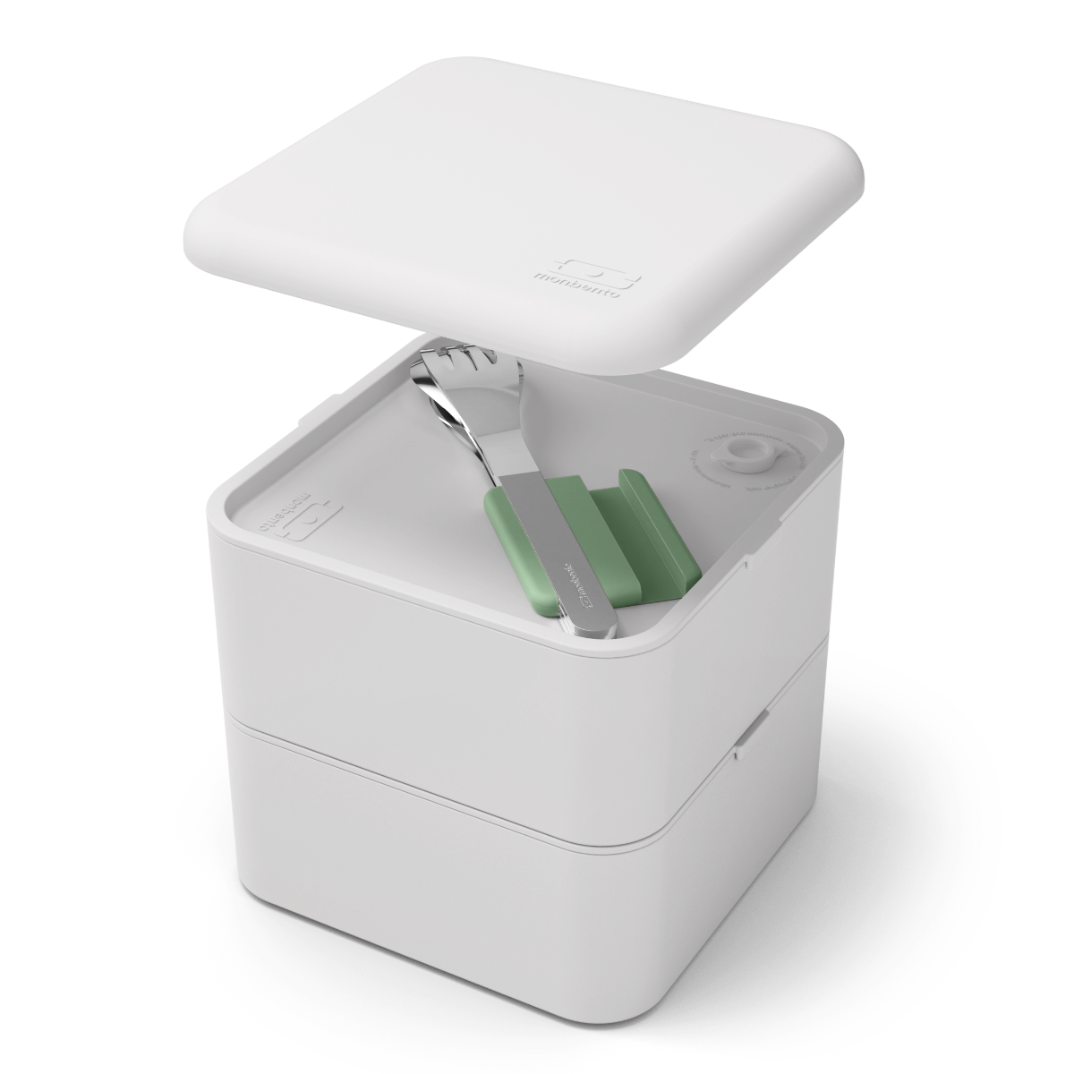 Vista superior de um conjunto de talheres Monbento em aço inox com suporte verde, inseridos num recipiente de almoço (bento box) branco.