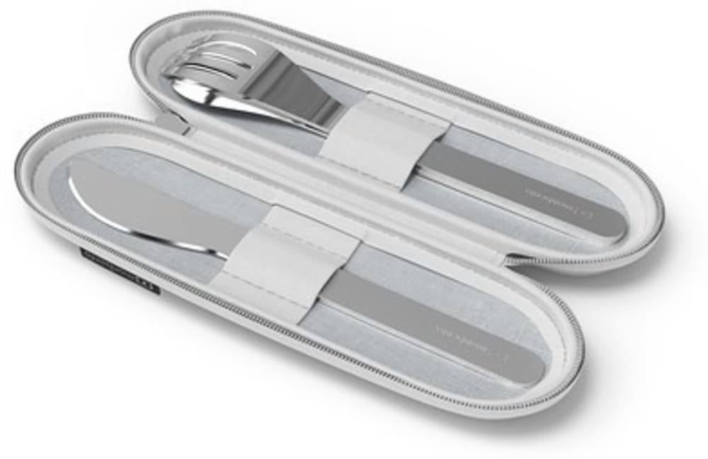 Detalhe dos talheres Monbento em aço inoxidável (garfo, faca e colher) fora da bolsa, focando no acabamento metálico e design ergonómico.