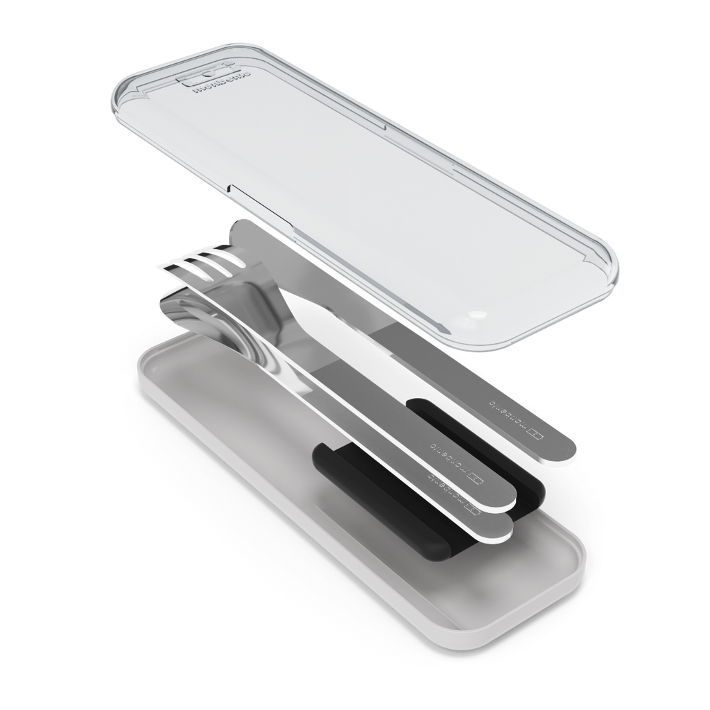 Os talheres Monbento (faca, garfo, colher) dispostos lado a lado, com a caixa de proteção PP/PC transparente ao fundo.