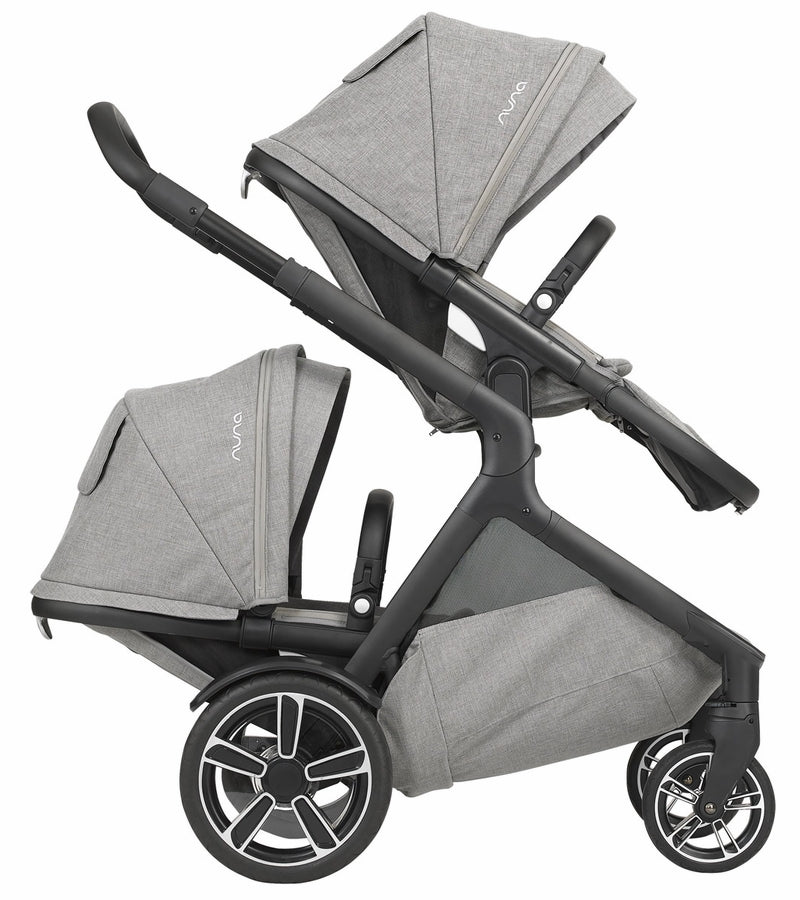 Carrinho Nuna Demi Grow configurado como carrinho duplo (twin), com dois assentos virados para a frente, em cor escura.