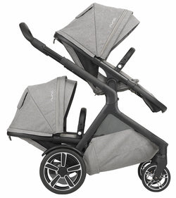 Carrinho Nuna Demi Grow configurado como carrinho duplo (twin), com dois assentos virados para a frente, em cor escura.