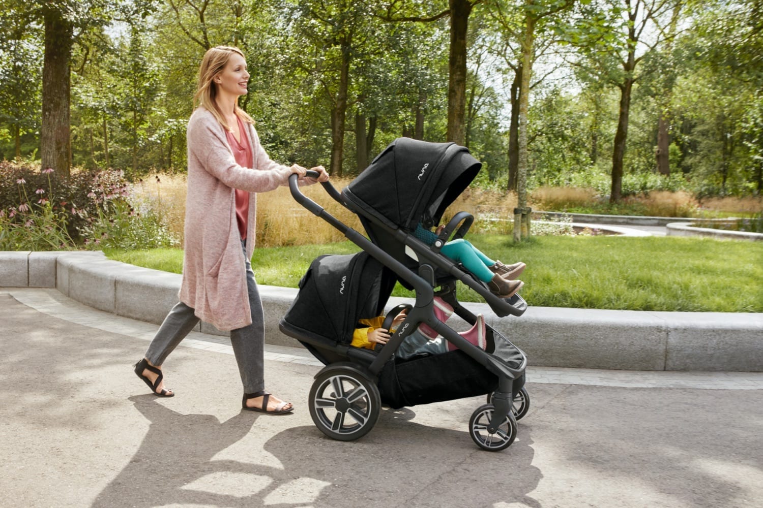 Vista lateral do carrinho Nuna Demi Grow com a capota extensível UPF 50+ totalmente aberta, protegendo o assento.