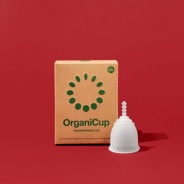 Embalagem de cartão e copo menstrual OrganiCup Mini sobre fundo vermelho.