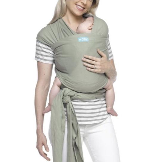 Mae a usar um Pano Elastico Moby Classic na cor verde oliva com o bebe colocado a frente