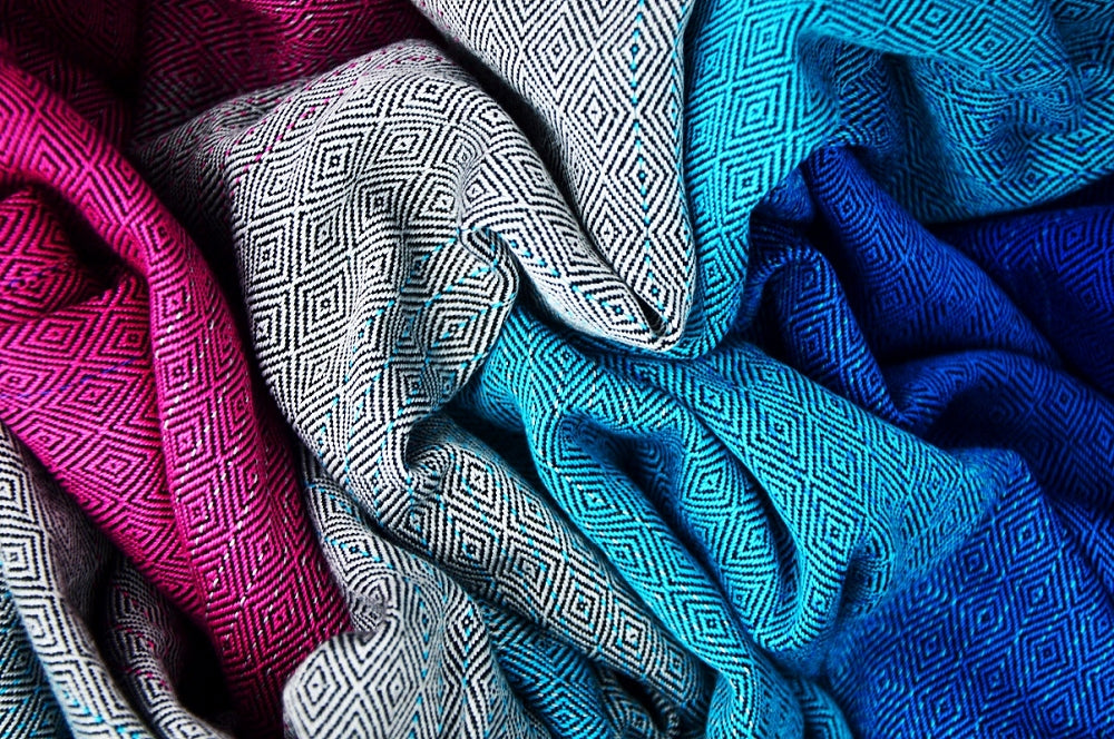 Pano tecido Sensimo Diamonds Ellen dobrado exibindo o padrão geométrico em tons de azul, rosa e branco.