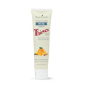 Tubo de pasta de dentes clareadora Thieves da Young Living com ilustrações de ingredientes naturais como laranja e cravo.