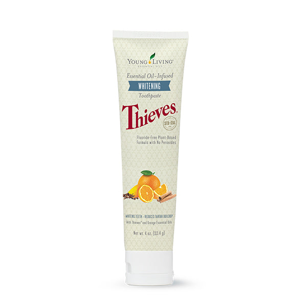 Tubo de pasta de dentes clareadora Thieves da Young Living com ilustrações de ingredientes naturais como laranja e cravo.
