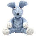 Peluche de coelho artesanal em tons de azul claro e branco, feito em crochet, sentado e com expressão amigável.