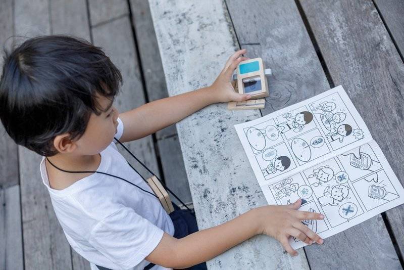 Todos os componentes do kit de agente secreto PlanToys dispostos: walkie-talkie, leitor de impressões, régua e cartão de identificação.