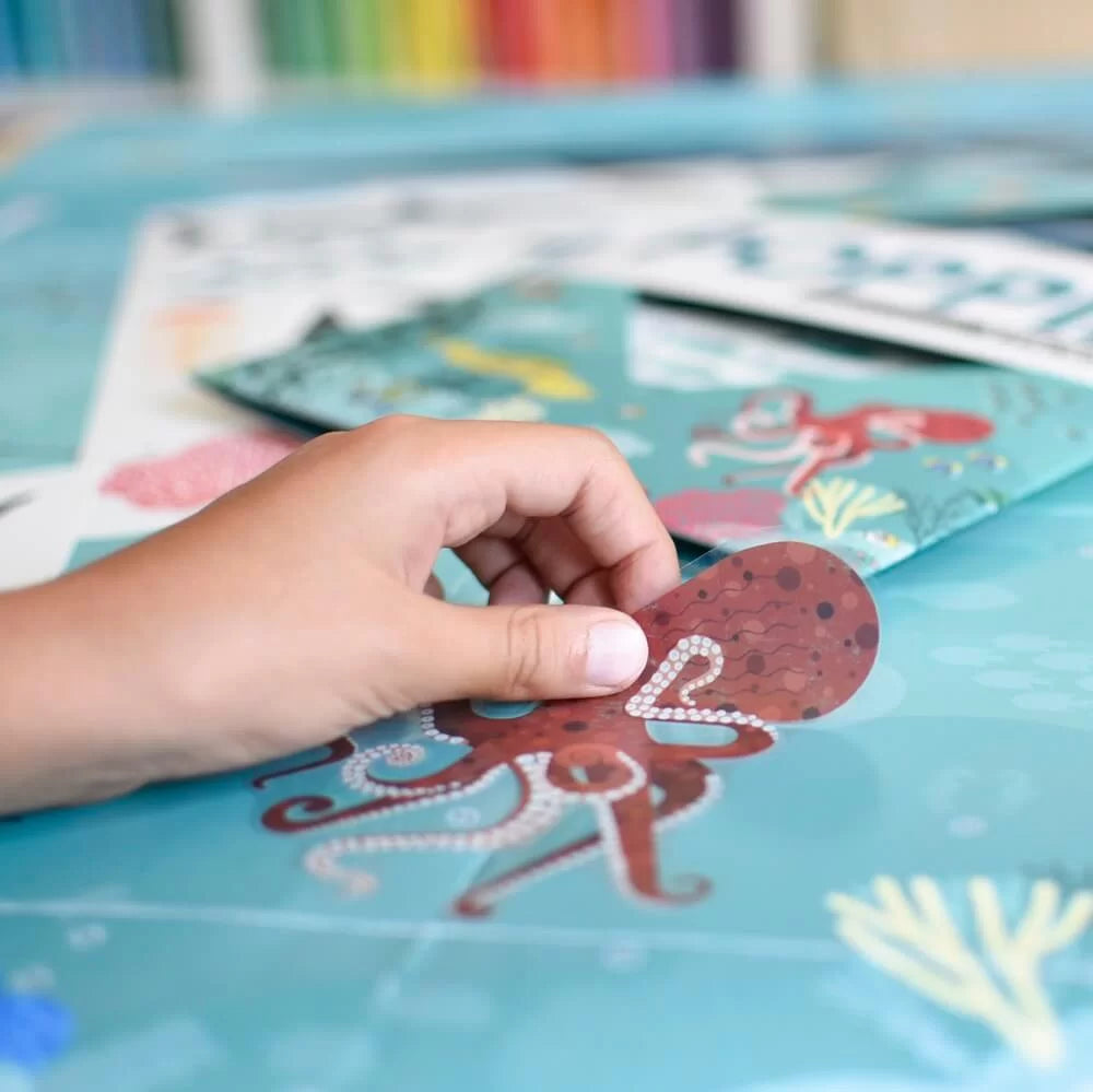 Conjunto completo do produto Poppik "Oceanos": poster gigante, folha com 59 autocolantes reposicionáveis e embalagem.