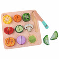 Vista superior do Classic World Puzzle de Cortar, mostrando vegetais coloridos como milho, pimentos, tomate e cogumelos, com uma faca de madeira.