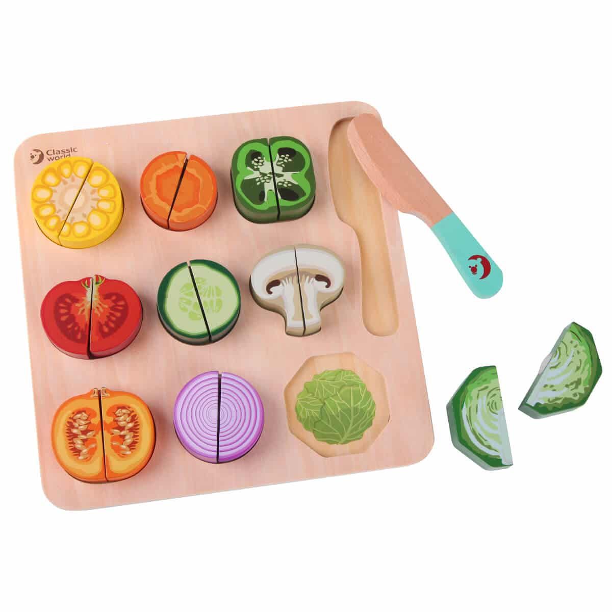 Vista superior do Classic World Puzzle de Cortar, mostrando vegetais coloridos como milho, pimentos, tomate e cogumelos, com uma faca de madeira.