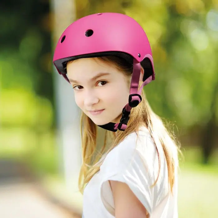 Criança a usar capacete Shoko rosa para proteção infantil 3-7 anos, 50-55cm, em ambiente exterior.