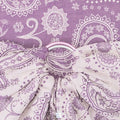 Mulher a carregar bebé no Sling de Argolas Fidella Persian Paisley Orchid em tons de roxo e lilás.
