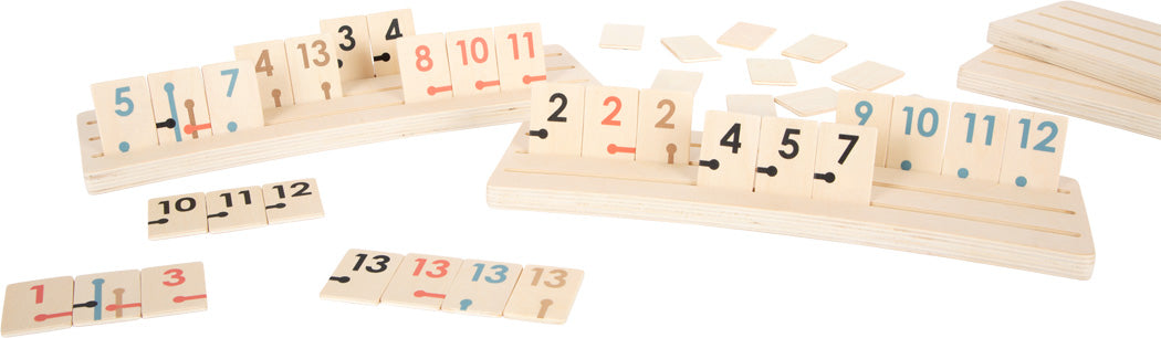 Jogo Rummy "Gold Edition" da small foot com peças de madeira em cores pastel e detalhes dourados, exposto em suportes pop-up.