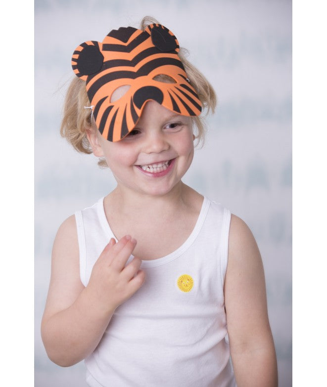 Criança com máscara de tigre e autocolante Squitos na camisola, ilustrando a diversão e proteção.