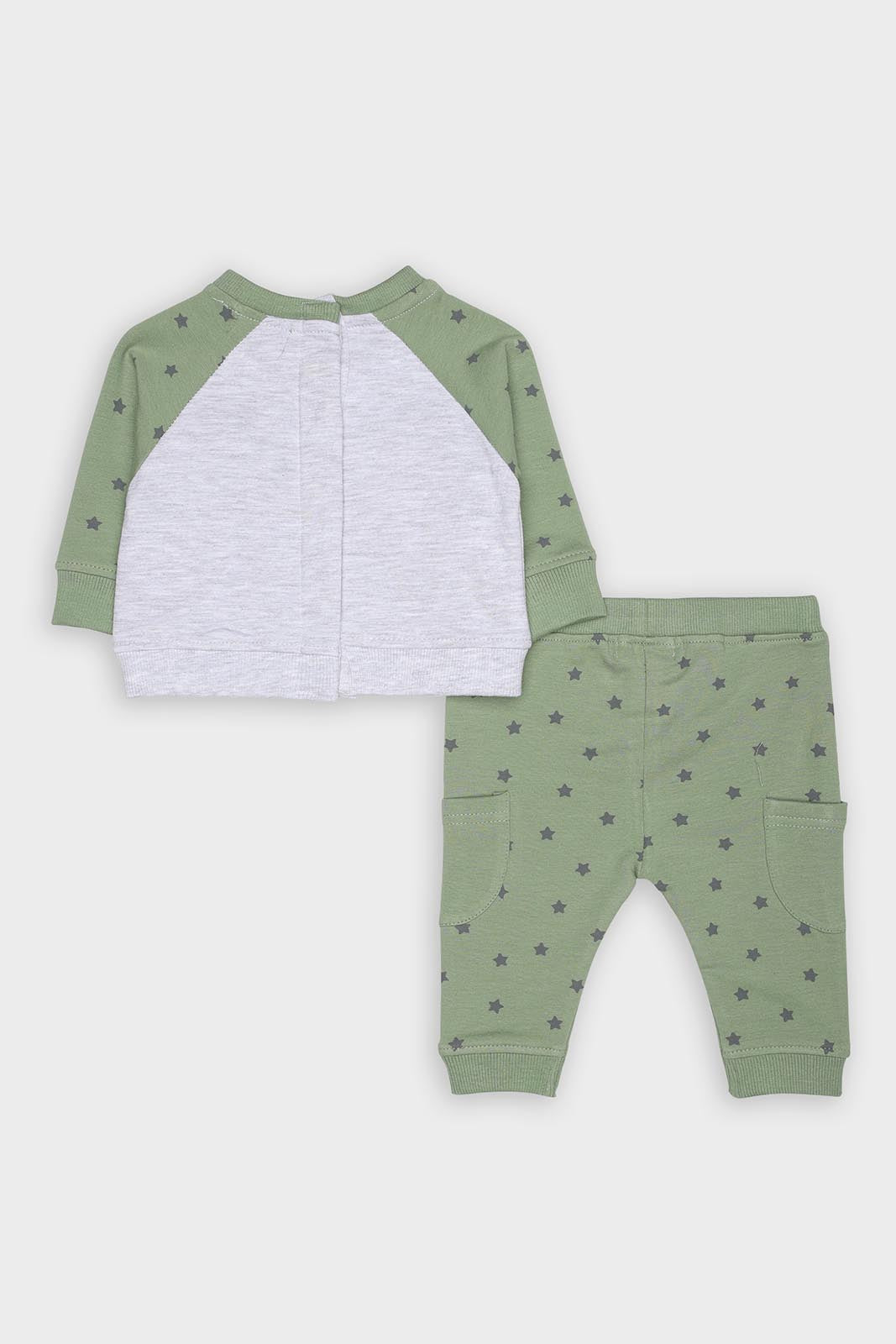 Detalhe da camisola verde folha do conjunto, mostrando o bolso frontal com aplicação de urso de peluche e botões de pressão nas costas.