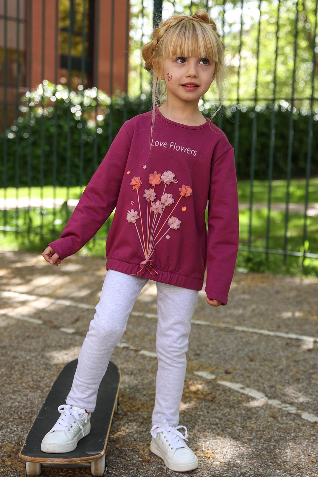 Conjunto infantil Street Monkey: sweatshirt roxa com estampa floral e legging cinza, apresentado em plano geral.