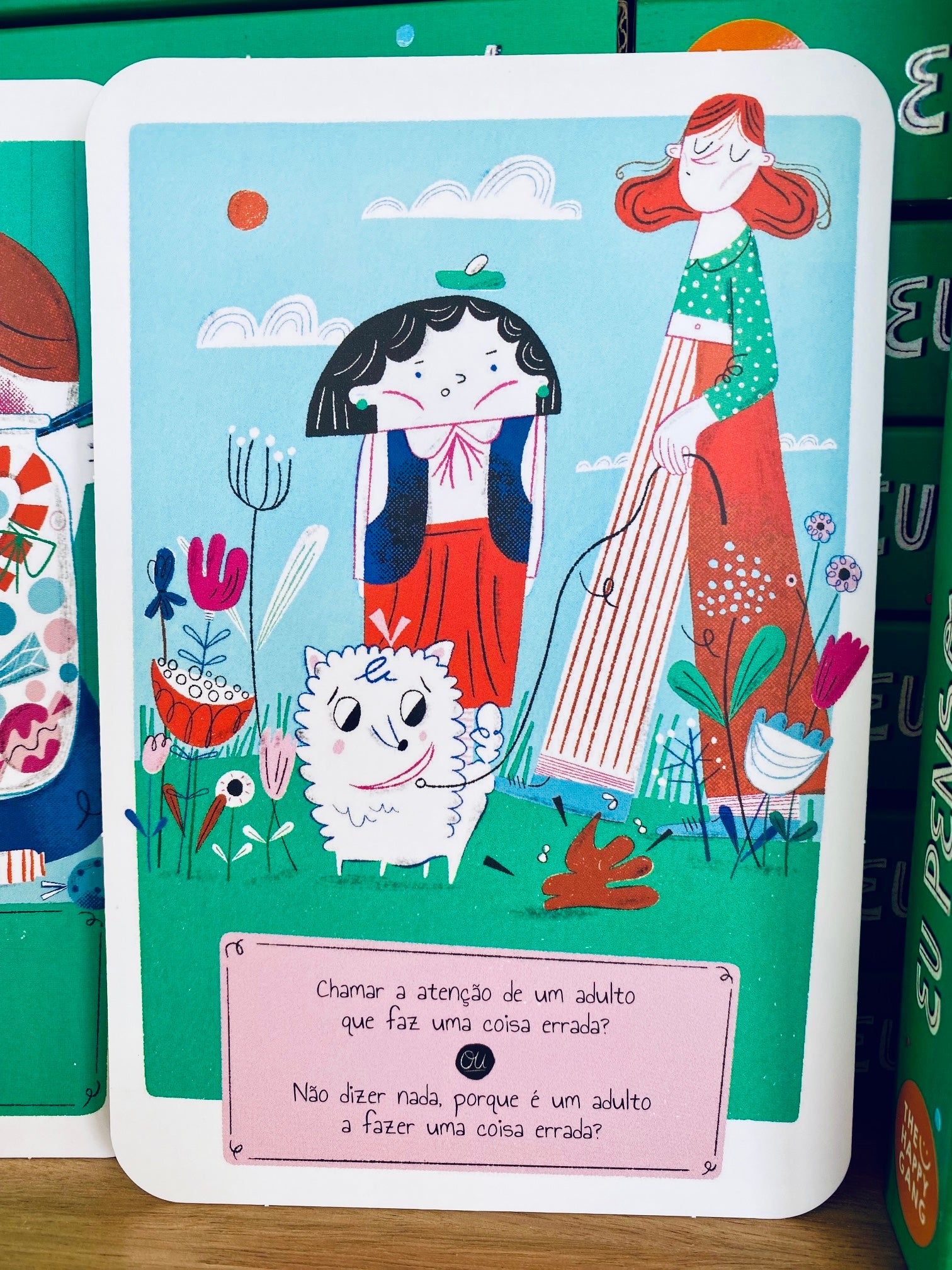 Vista aérea das 34 cartas do jogo dispostas em leque, evidenciando a variedade de temas éticos e de civismo abordados para crianças +5 anos.