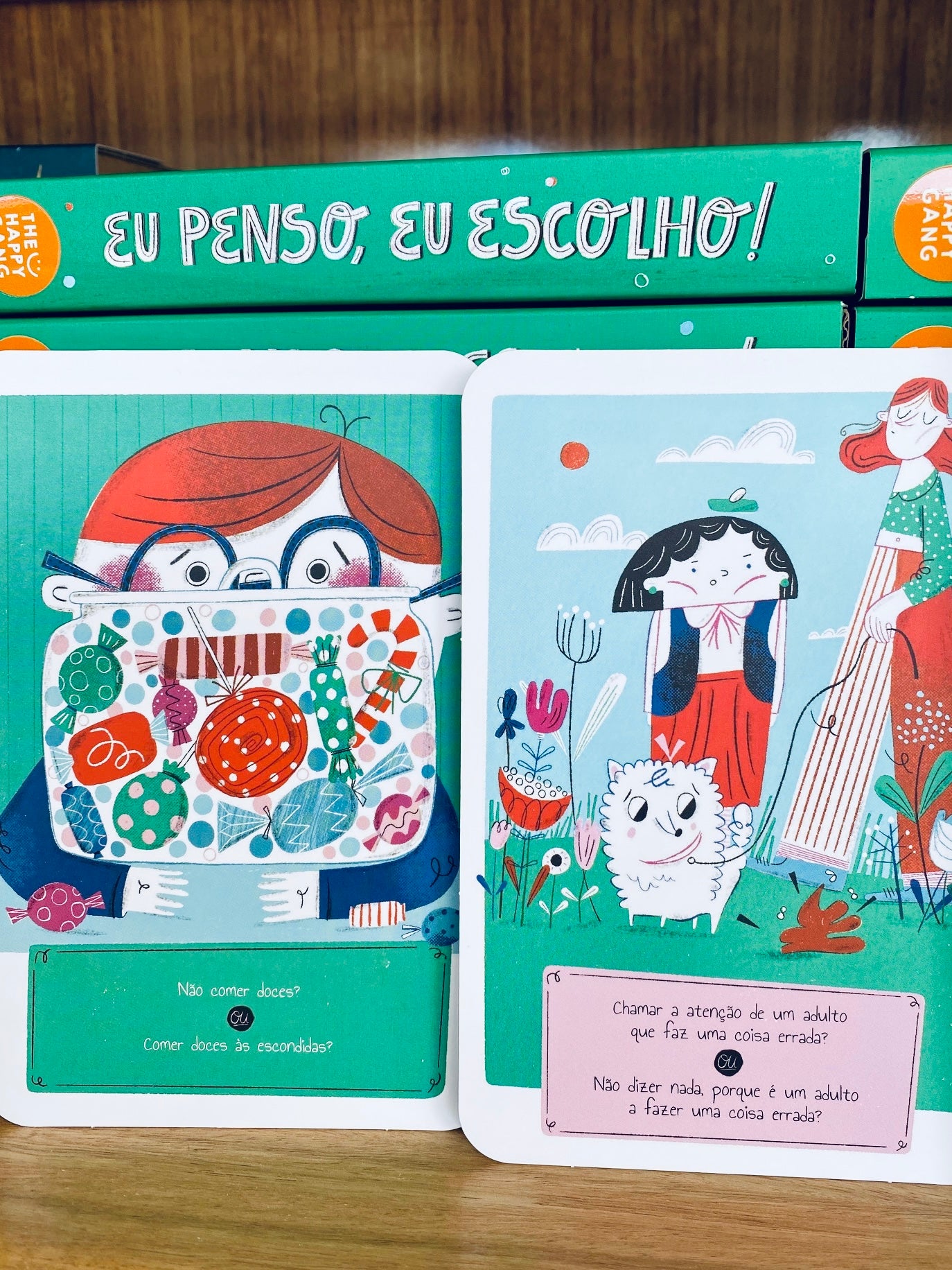 O livro de apoio do jogo "Eu Penso, Eu Escolho" aberto, com texto visível e ilustrações, explicando como explorar as razões das decisões.