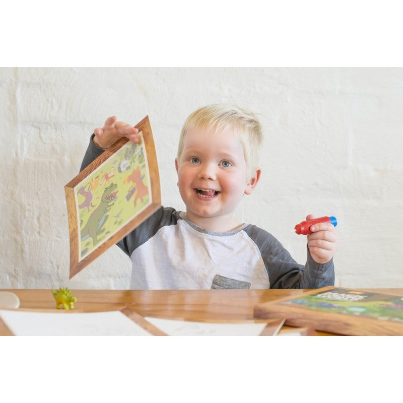 Criança a usar o pincel mágico com água para revelar cores vibrantes num dos quadros de atividade Tiger Tribe.