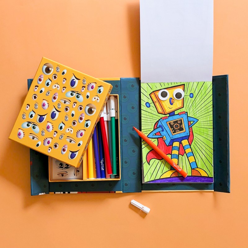 Imagem do conjunto Tiger Tribe "Crazy Eyes Creatures" aberto, mostrando o conteúdo: páginas para colorir, marcadores, e autocolantes de olhos.