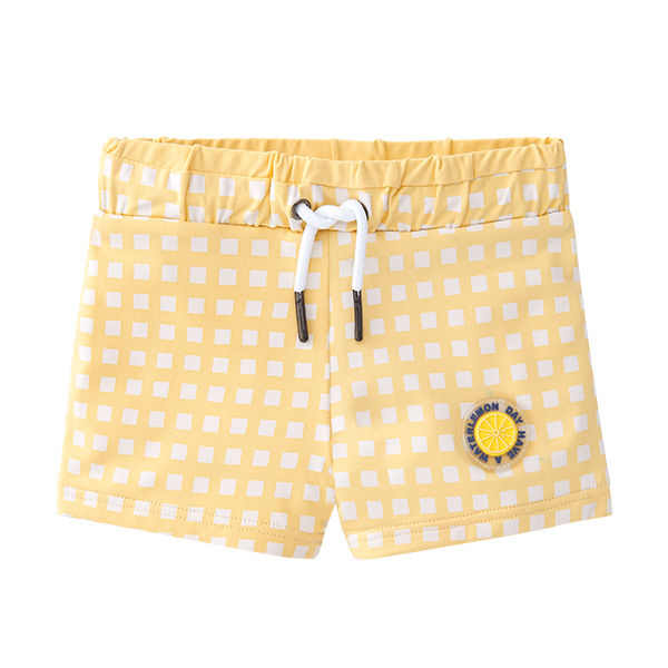 Vista frontal do calção de praia Waterlemon para menino, em lycra xadrez amarelo/branco, com cós elástico e cordão branco.