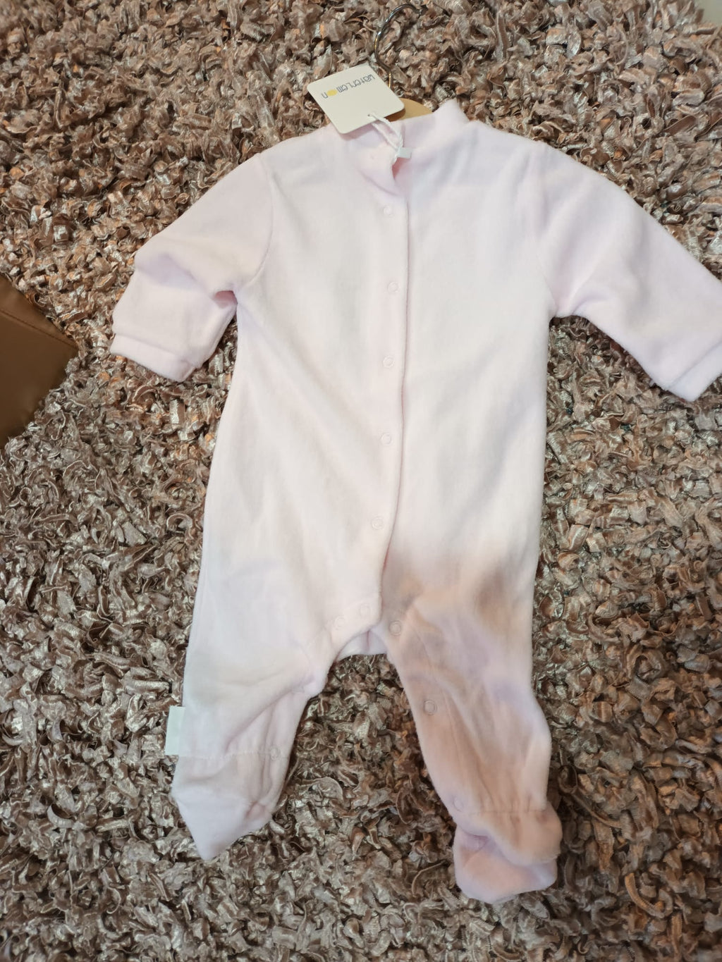 Detalhe da gola redonda e mangas compridas do babygrow Unicórnio Rosa, mostrando a textura suave do tecido de algodão.