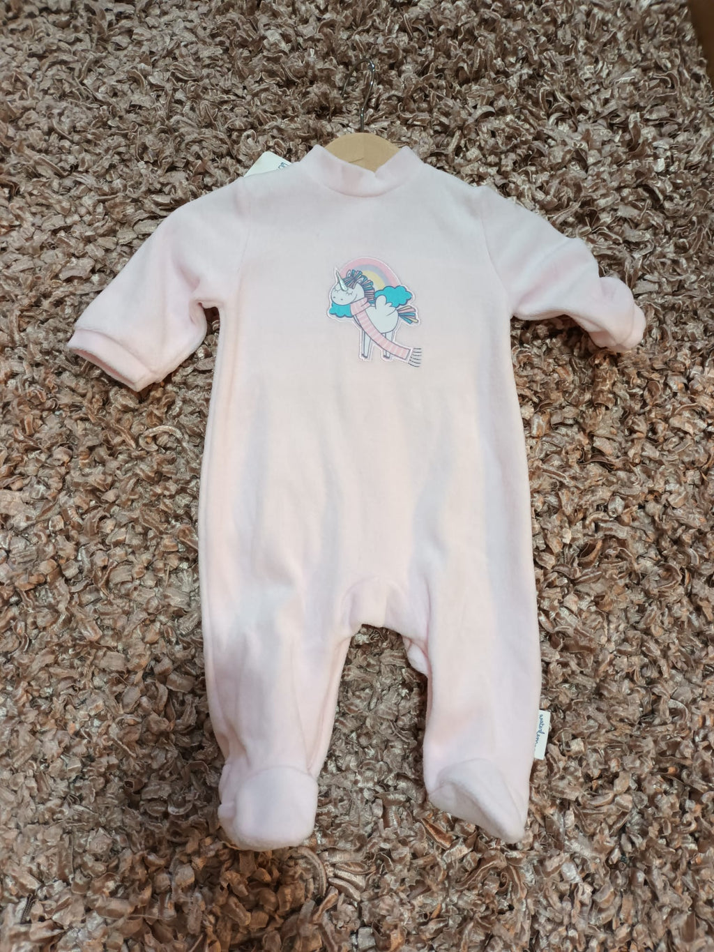 Pijama babygrow Waterlemon Unicórnio Rosa, vista frontal completa, com padrão de unicórnios e fecho de molas no ombro.