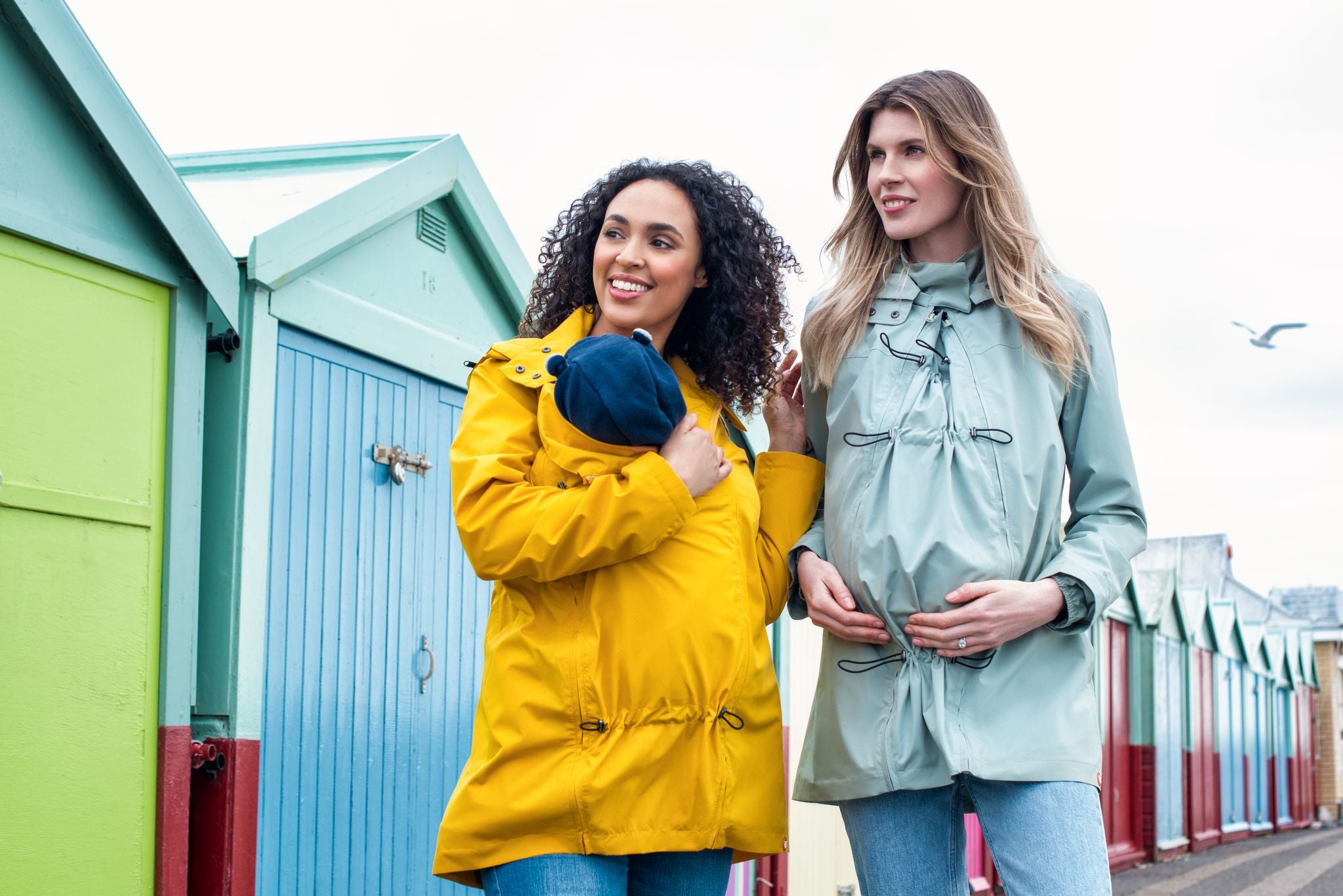 Casaco de transporte Wombat Numbat GO cinzento, usado por uma mulher com um bebé no painel frontal. Foco na funcionalidade 4 em 1.